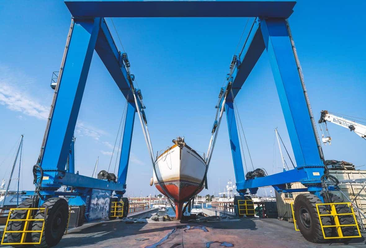 boat being lifted out of the water by machinery