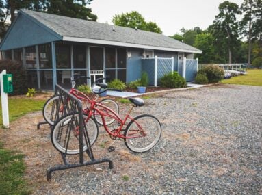 2 red bikes parked in front of a small building