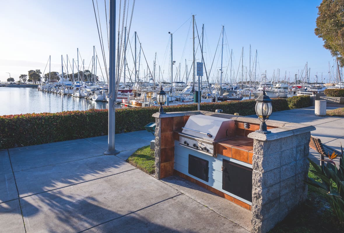 an outdoor barbecue next to a marina