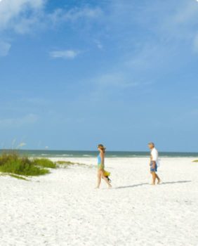 two people walking on a beach