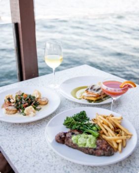 des plats de fruits de mer posés sur une table au bord de l'eau