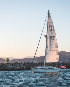 velero junto a una costa rocosa