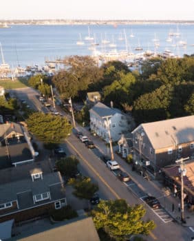 aerial view of street with houses and stores on it next to a marina