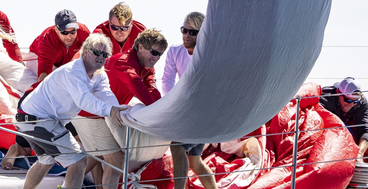 Cinq hommes tirant sur une voile