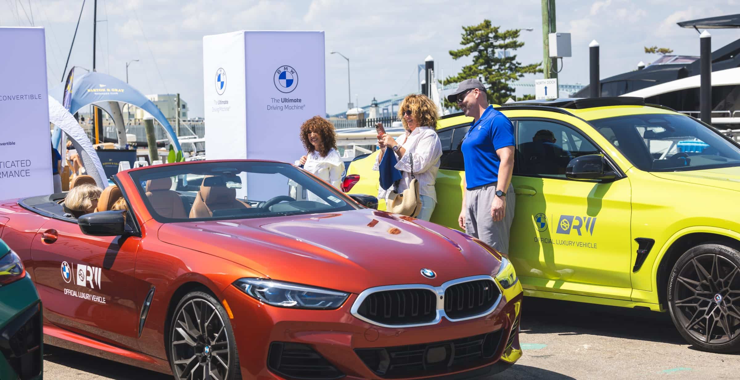 Una mujer sonriente haciendo una foto a un BMW